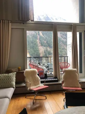 a living room with two chairs in front of a large window at Design loft in Chamonix Center in Chamonix-Mont-Blanc
