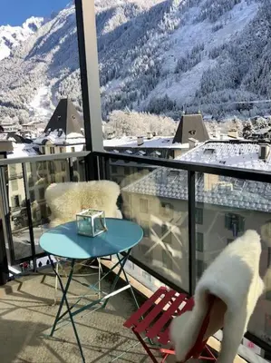 a balcony with a table and chairs and a mountain at Design loft in Chamonix Center in Chamonix-Mont-Blanc