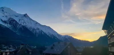 a mountain in the distance with a city and buildings at Les Pècles Mt Blanc - Chamonix Center in Chamonix-Mont-Blanc