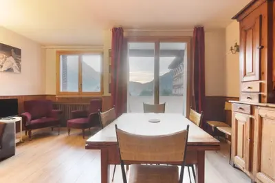 a dining room with a table and chairs and a window at Les Pècles Mt Blanc - Chamonix Center in Chamonix-Mont-Blanc