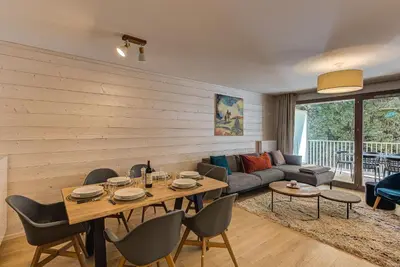 a living room with a table and chairs and a couch at White Pearl A13 - Alpes Travel - Central Chamonix (Sleeps 6) in Chamonix-Mont-Blanc