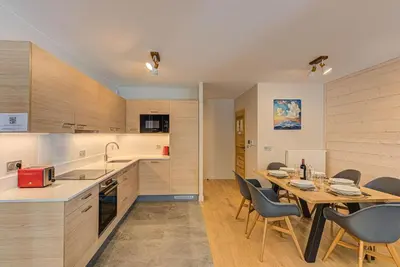 a kitchen and dining room with a table and chairs at White Pearl A13 - Alpes Travel - Central Chamonix (Sleeps 6) in Chamonix-Mont-Blanc