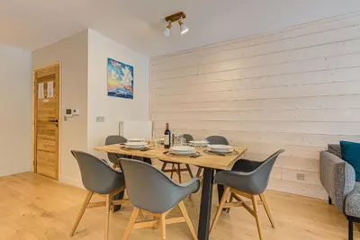 a dining room with a wooden table and chairs at White Pearl A13 - Alpes Travel - Central Chamonix (Sleeps 6) in Chamonix-Mont-Blanc