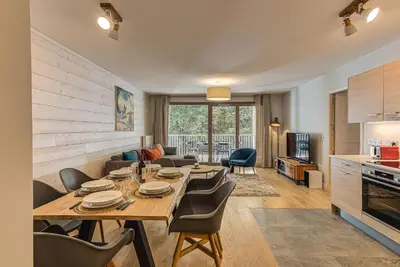 a dining room and living room with a table and chairs at White Pearl A13 - Alpes Travel - Central Chamonix (Sleeps 6) in Chamonix-Mont-Blanc