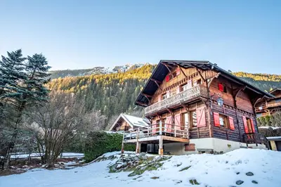 a large wooden house on a snow covered hill at Primerose - Historic Chalet - Garden - Central - 5 bedrooms - Mont-Blanc Views in Chamonix-Mont-Blanc