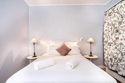 a bedroom with a white bed with two lamps at Primerose - Historic Chalet - Garden - Central - 5 bedrooms - Mont-Blanc Views in Chamonix-Mont-Blanc