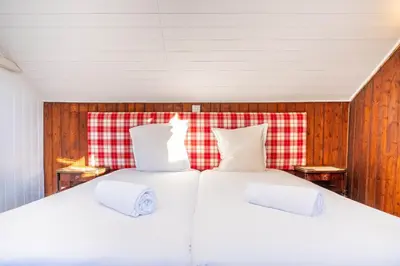 a bedroom with two beds and a red and white blanket at Primerose - Historic Chalet - Garden - Central - 5 bedrooms - Mont-Blanc Views in Chamonix-Mont-Blanc
