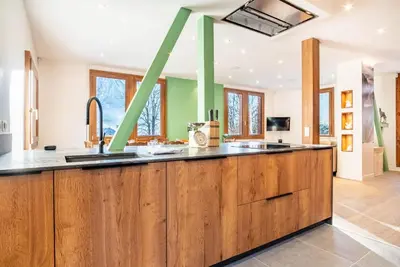 a kitchen with wooden cabinets and a large island at Primerose - Historic Chalet - Garden - Central - 5 bedrooms - Mont-Blanc Views in Chamonix-Mont-Blanc