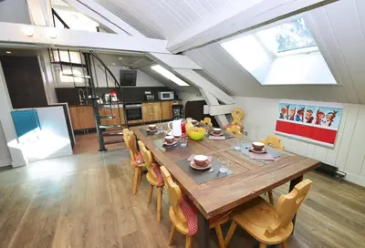 a kitchen and dining room with a wooden table and chairs at Appartement Bellevue - centre ville in Chamonix-Mont-Blanc