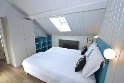 a bedroom with a white bed and a skylight at Appartement Bellevue - centre ville in Chamonix-Mont-Blanc