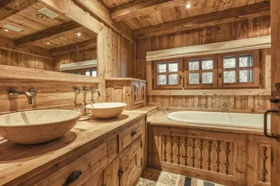 a wooden bathroom with two sinks and a tub at Chalet Edelweiss in Megève
