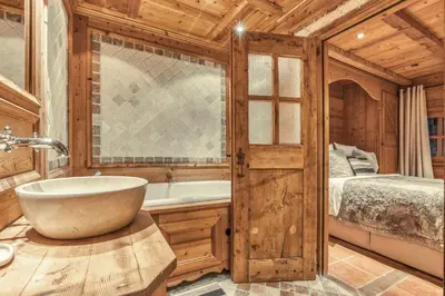 a bathroom with a tub and a bed and a sink at Chalet Edelweiss in Megève