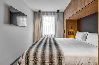 a bedroom with a large white bed and a window at Kristal in Megève