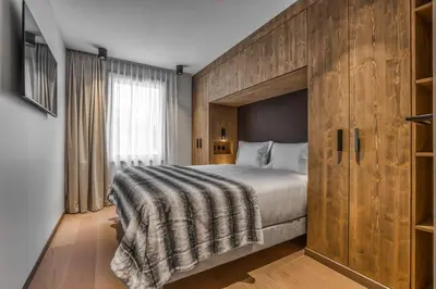 a bedroom with a large bed with a wooden headboard at Kristal in Megève