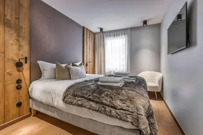 a bedroom with a bed and a tv on a wall at Kristal in Megève
