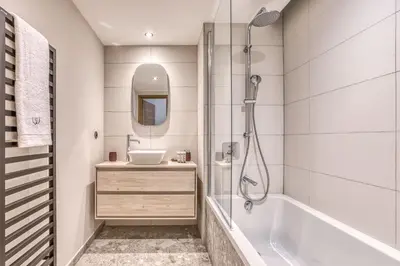 a bathroom with a tub and a sink and a shower at Kristal in Megève
