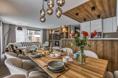 a dining room with a wooden table and chairs at Kristal in Megève