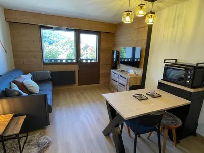 a living room with a blue couch and a table at Studio familial pour 4 personnes avec parking à Samoëns - FR-1-629-122 in Samoëns