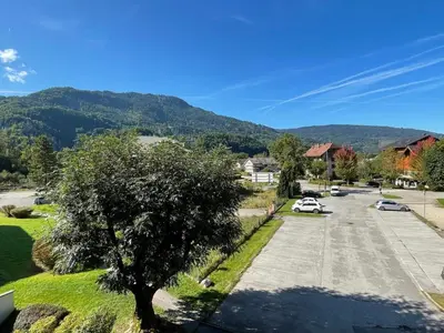 a tree in the middle of a street with a mountain at Studio familial pour 4 personnes avec parking à Samoëns - FR-1-629-122 in Samoëns