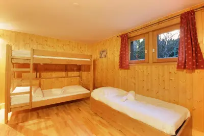two bunk beds in a room with wooden walls at Chalet Ancelles - Les Praz - Golf - Vue Mont-Blanc - Randonnées in Chamonix-Mont-Blanc