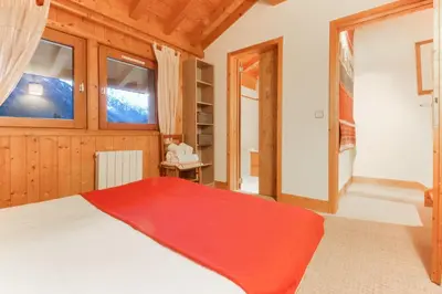a bedroom with a bed with a red blanket at Chalet Ancelles - Les Praz - Golf - Vue Mont-Blanc - Randonnées in Chamonix-Mont-Blanc