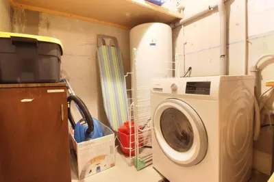 a laundry room with a washing machine and a tv at Chalet Ancelles - Les Praz - Golf - Vue Mont-Blanc - Randonnées in Chamonix-Mont-Blanc