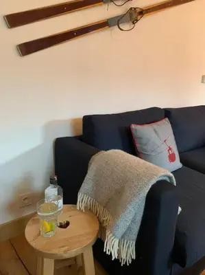 a living room with a blue couch and a table at Pom Pom, 3 bedroom apt with stunning mountain views-Samoëns in Samoëns