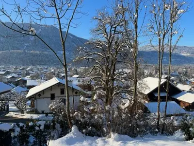 a snow covered village with houses and trees at Pom Pom, 3 bedroom apt with stunning mountain views-Samoëns in Samoëns