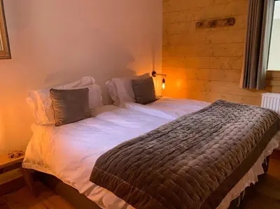 a bedroom with a large bed with white sheets at Pom Pom, 3 bedroom apt with stunning mountain views-Samoëns in Samoëns