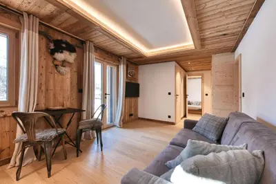 a bedroom with a white bed and wooden ceilings at Plein soleil in Saint-Gervais-les-Bains