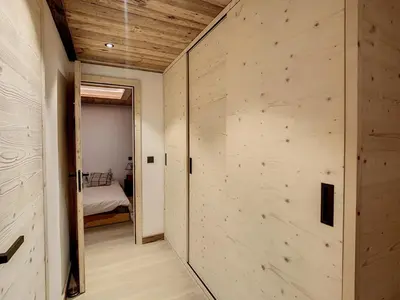 a room with a wooden wall and a bedroom at Plein soleil in Saint-Gervais-les-Bains