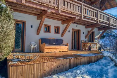a living room with a couch and a table and chairs at Plein soleil in Saint-Gervais-les-Bains