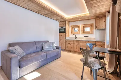 a kitchen with a sink and wooden cabinets at Plein soleil in Saint-Gervais-les-Bains