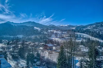 a town covered in snow with mountains in the background at Plein soleil in Saint-Gervais-les-Bains