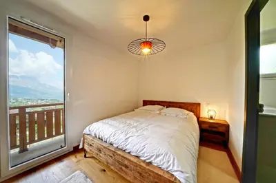 a bedroom with a bed and a large window at Magnifique Chalet neuf 8 pers, 800 m télécabine Princesse Megeve in Combloux