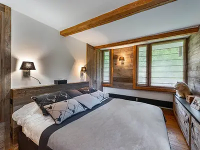 a bedroom with a large bed in a room with wooden walls at Appartement à Megève, proche ski et golf - FR-1-569-67 in Megève