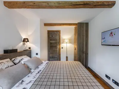a bedroom with a large bed with a tiled floor at Appartement à Megève, proche ski et golf - FR-1-569-67 in Megève