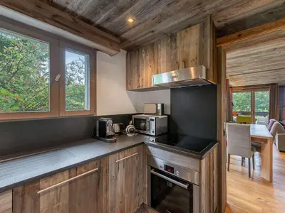 a kitchen with wooden cabinets and a stove top oven at Appartement à Megève, proche ski et golf - FR-1-569-67 in Megève