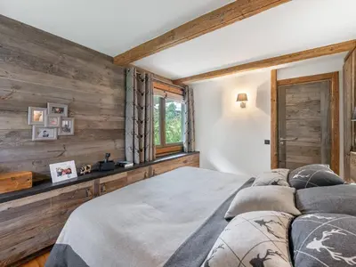 a bedroom with a large bed and wooden walls at Appartement à Megève, proche ski et golf - FR-1-569-67 in Megève