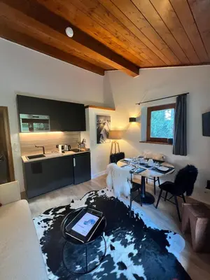 a living room with a table and a kitchen at N5 Megève - Résidence de L'ours - appart 4 pers in Megève