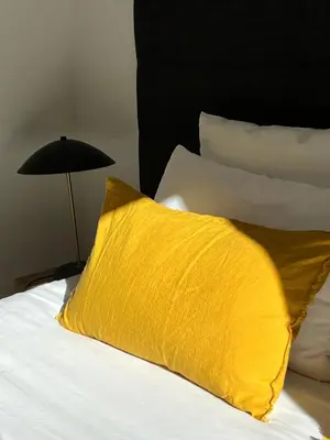 a yellow pillow sitting on a bed next to a lamp at N5 Megève - Résidence de L'ours - appart 4 pers in Megève