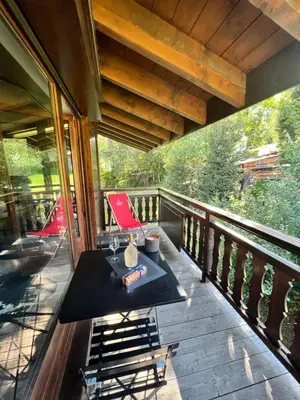 a porch with a table and chairs on a deck at N5 Megève - Résidence de L'ours - appart 4 pers in Megève