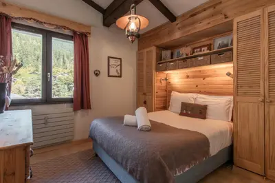 a bedroom with a bed with a wooden wall at Cristal des Glaces 2 - Lac de Gailland - Randonnée - Escalade - Central in Chamonix-Mont-Blanc
