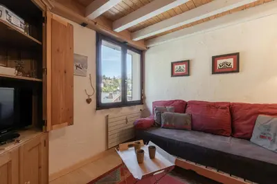 a living room with a red couch and a window at Cristal des Glaces 2 - Lac de Gailland - Randonnée - Escalade - Central in Chamonix-Mont-Blanc