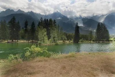 a lake with trees and mountains in the background at Cristal des Glaces 2 - Lac de Gailland - Randonnée - Escalade - Central in Chamonix-Mont-Blanc