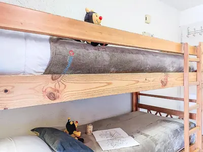 a room with a bunk bed with a book and a toy at Studio Les Collybies by Interhome in Saint-Gervais-les-Bains