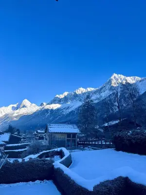 a snow covered mountain in front of a building at Kinabalu - Vue Mt Blanc Range Les houches center in Les Houches