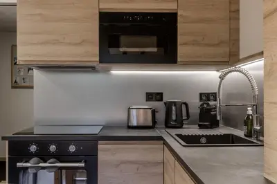 a kitchen with a stove and a microwave at Kinabalu - Vue Mt Blanc Range Les houches center in Les Houches