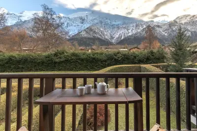a table on a balcony with a view of mountains at Kinabalu - Vue Mt Blanc Range Les houches center in Les Houches