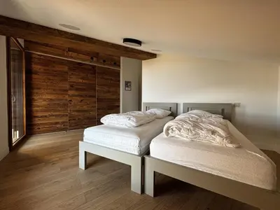 a bedroom with two beds and a wooden wall at Appartement de standing, au pied des pistes avec parking et WIFI, Les Carroz d'Arâches - FR-1-572-280 in Arâches-la-Frasse